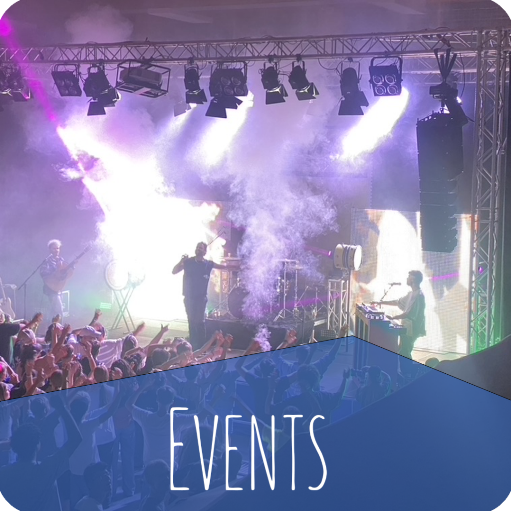 Event mit Bühne, Lichtshow und Publikum in einer Halle mit Schriftzug „Events“ – Evangelische Gesellschaft für Deutschland KdöR
