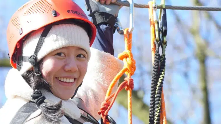 Lächelndes Mädchen mit Helm beim Klettern in Nahaufnahme – Evangelische Gesellschaft für Deutschland KdöR